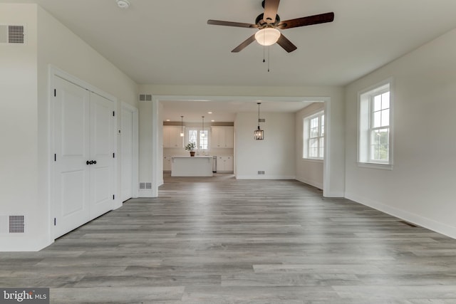 unfurnished living room featuring ceiling fan and light wood-type flooring