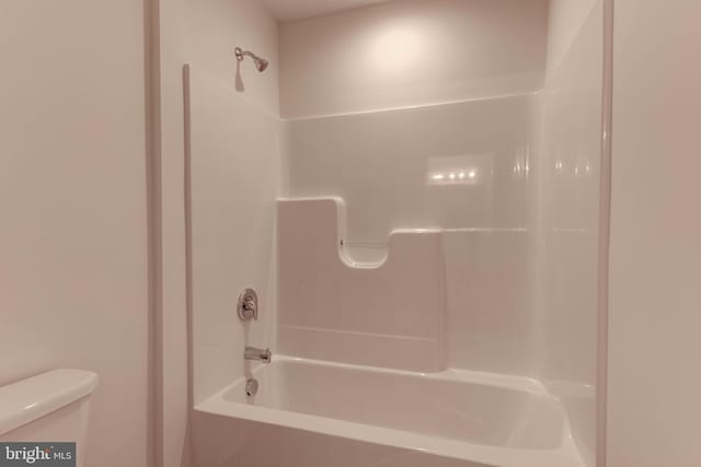 bathroom featuring tub / shower combination and toilet