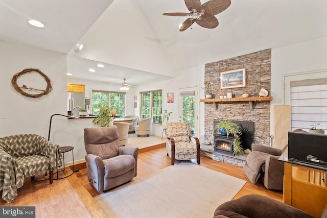 living room featuring ceiling fan, high vaulted ceiling, and light wood-type flooring