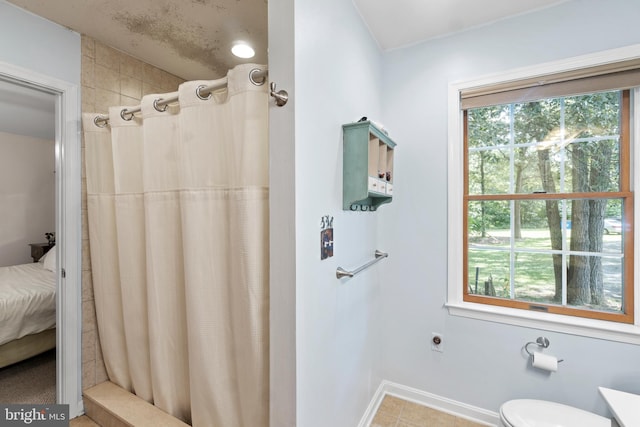 bathroom with toilet and a shower with curtain