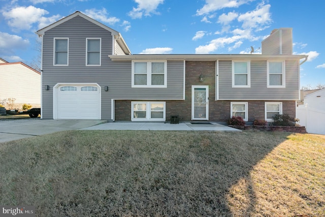 raised ranch with a garage and a front lawn