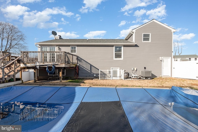 rear view of property with central AC and a swimming pool side deck