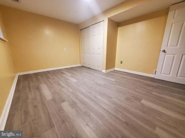 unfurnished bedroom with a closet and light hardwood / wood-style floors