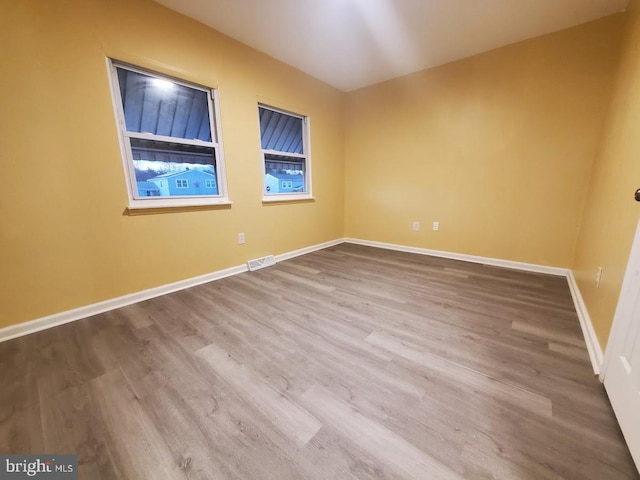 unfurnished room with hardwood / wood-style flooring