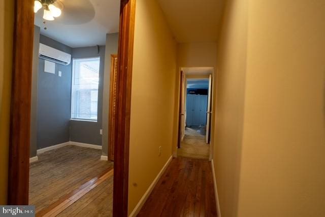 hallway featuring an AC wall unit and hardwood / wood-style floors