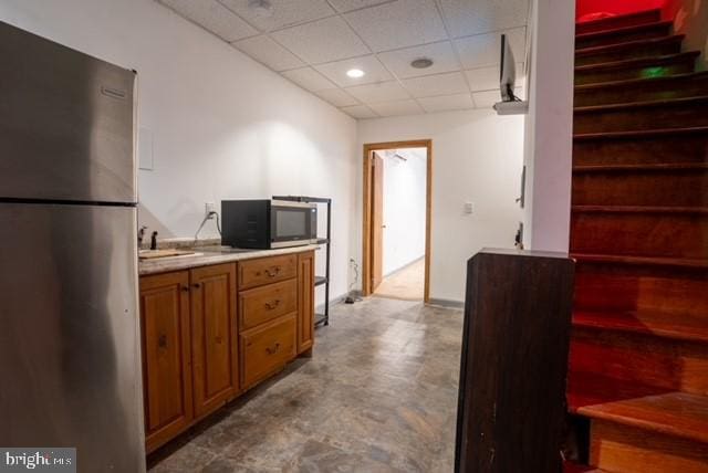 kitchen featuring appliances with stainless steel finishes, a drop ceiling, and sink