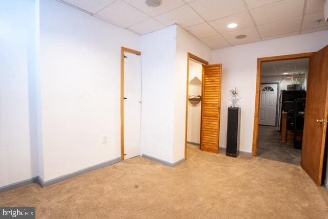 unfurnished bedroom featuring a paneled ceiling and carpet floors