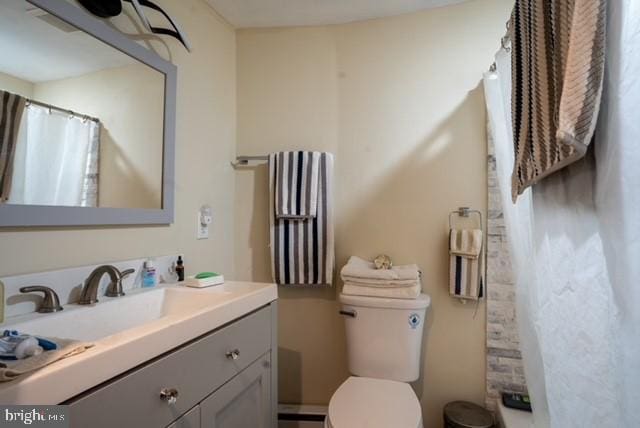 bathroom with toilet, vanity, and a shower with shower curtain