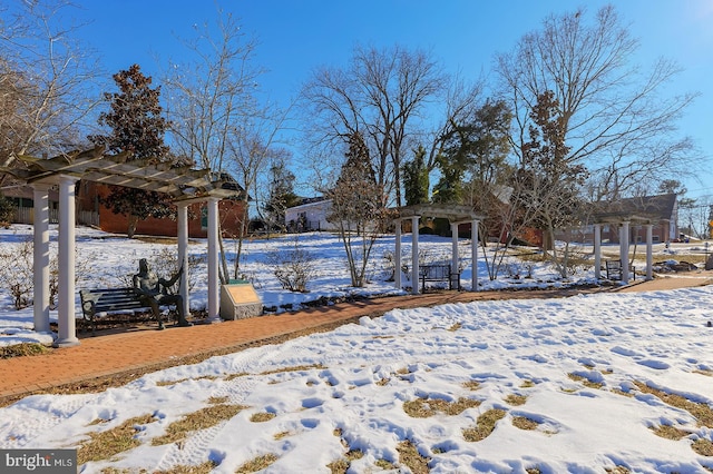 yard layered in snow with a pergola