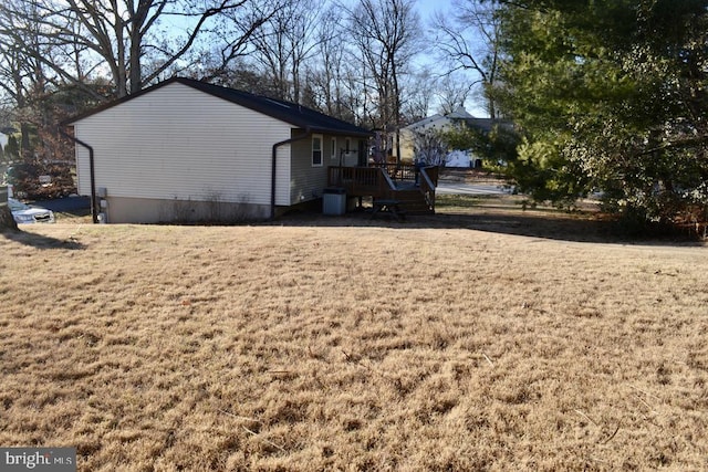 view of property exterior with a wooden deck and a yard