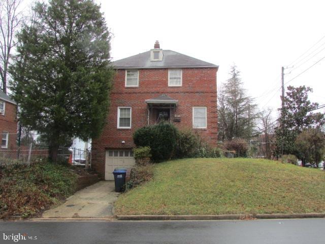 view of front of home with a front lawn and a garage