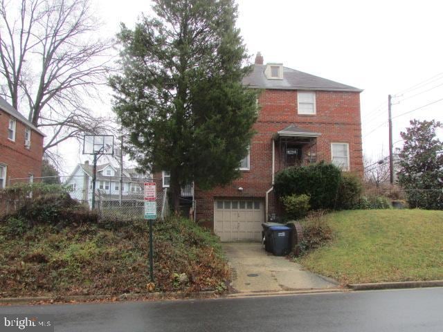 view of front of property featuring a front lawn and a garage