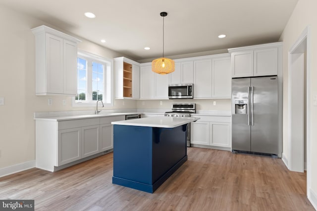 kitchen with stainless steel appliances, white cabinets, and hanging light fixtures