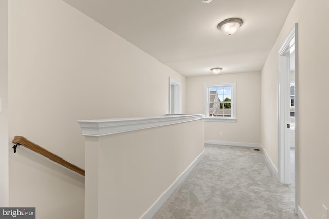 corridor featuring light colored carpet