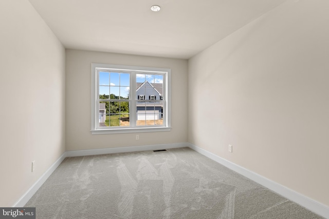 spare room featuring light colored carpet