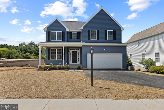 view of front of home with central air condition unit and a garage