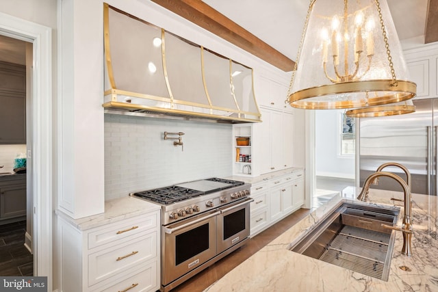 kitchen with white cabinetry, sink, backsplash, and high end appliances