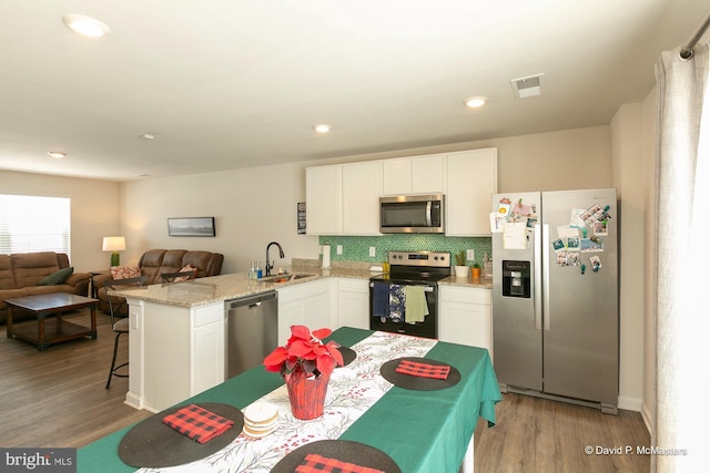 kitchen with sink, white cabinetry, kitchen peninsula, and appliances with stainless steel finishes