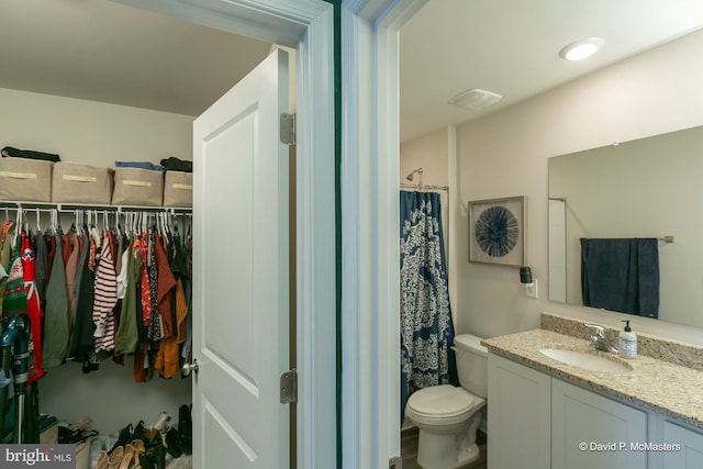 bathroom with curtained shower, toilet, and vanity