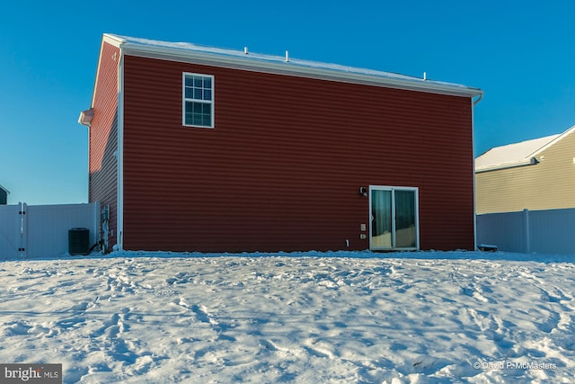 snow covered property with central air condition unit