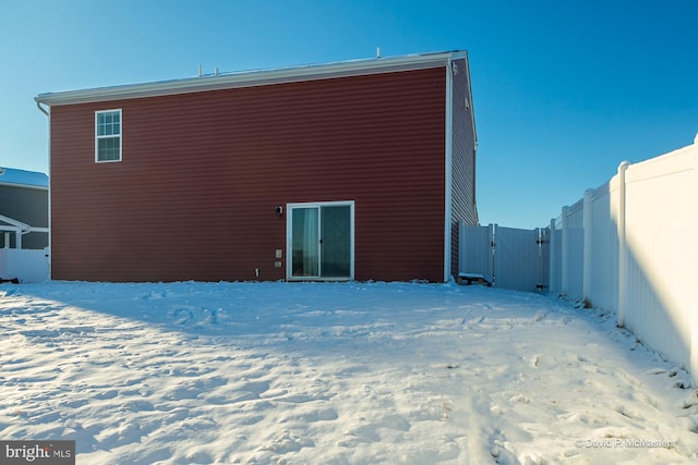 view of snow covered rear of property