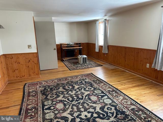 living room featuring wooden walls and light hardwood / wood-style floors