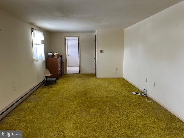 unfurnished room with a baseboard radiator and carpet