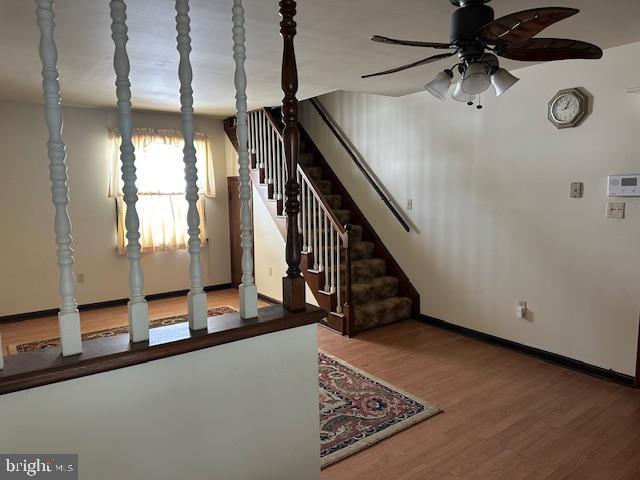 stairway featuring hardwood / wood-style floors and ceiling fan