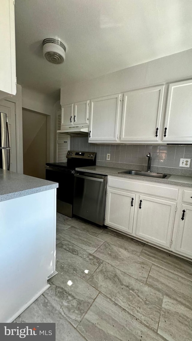 kitchen with white cabinets, decorative backsplash, sink, and stainless steel appliances