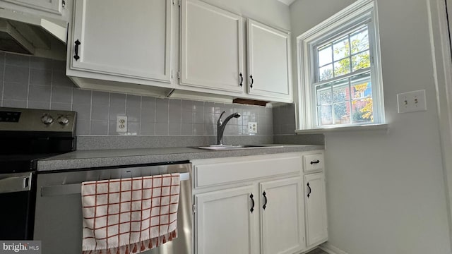 kitchen with stainless steel electric stove, dishwasher, white cabinetry, tasteful backsplash, and sink