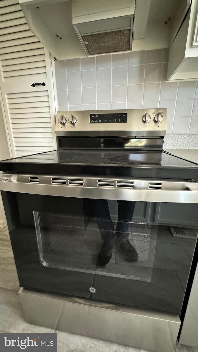 details featuring stainless steel electric stove and backsplash