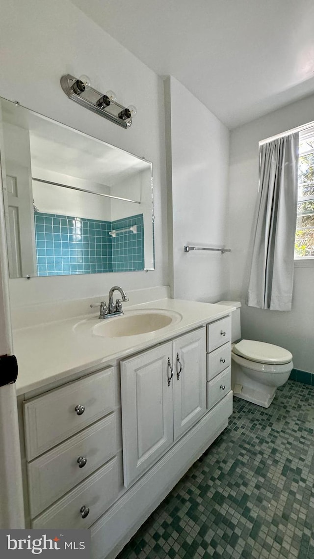 bathroom featuring toilet, tile patterned floors, and vanity