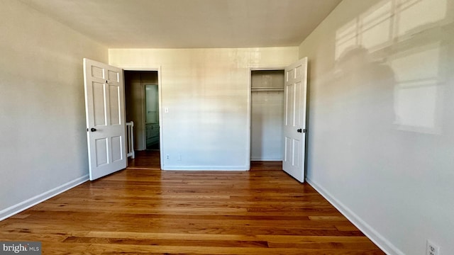 unfurnished bedroom with a closet and dark hardwood / wood-style flooring