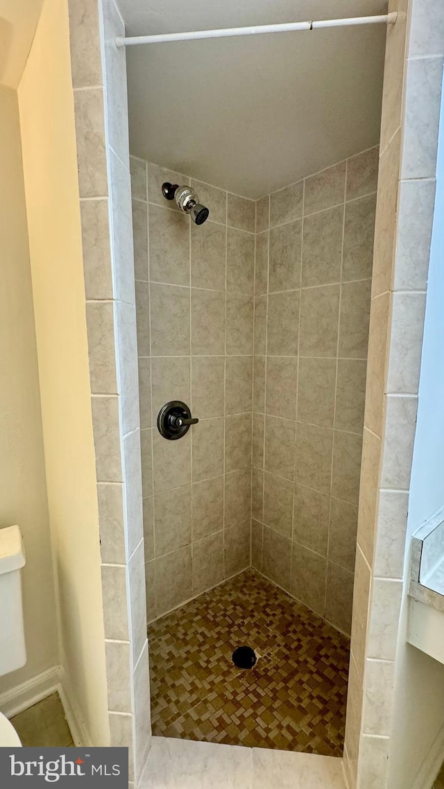 bathroom with toilet and tiled shower