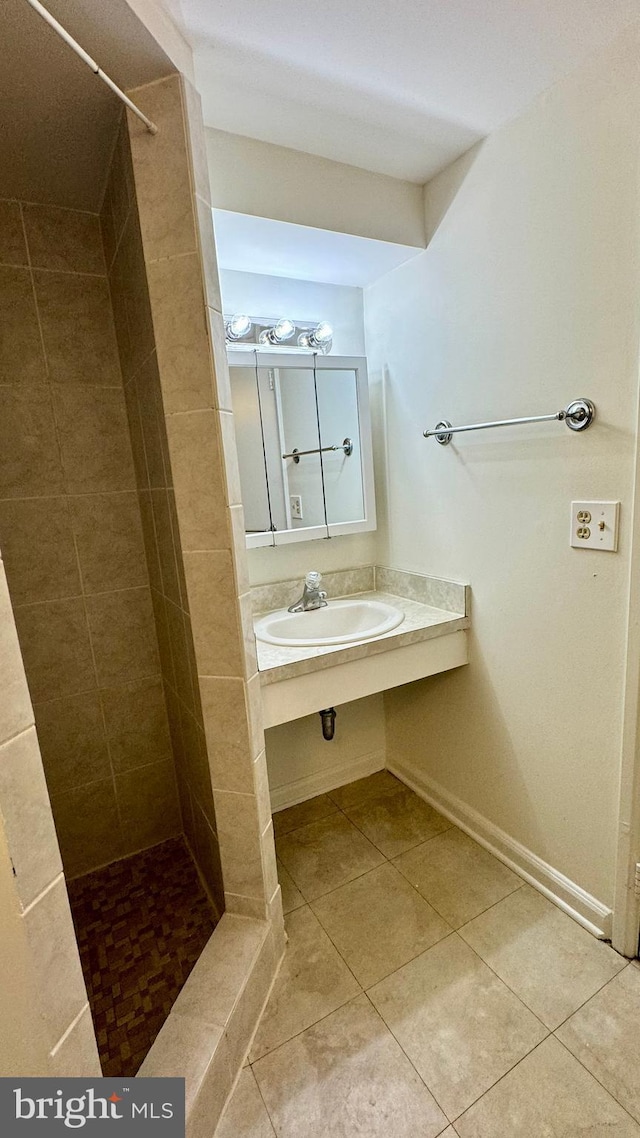 bathroom with sink, tile patterned floors, and a tile shower