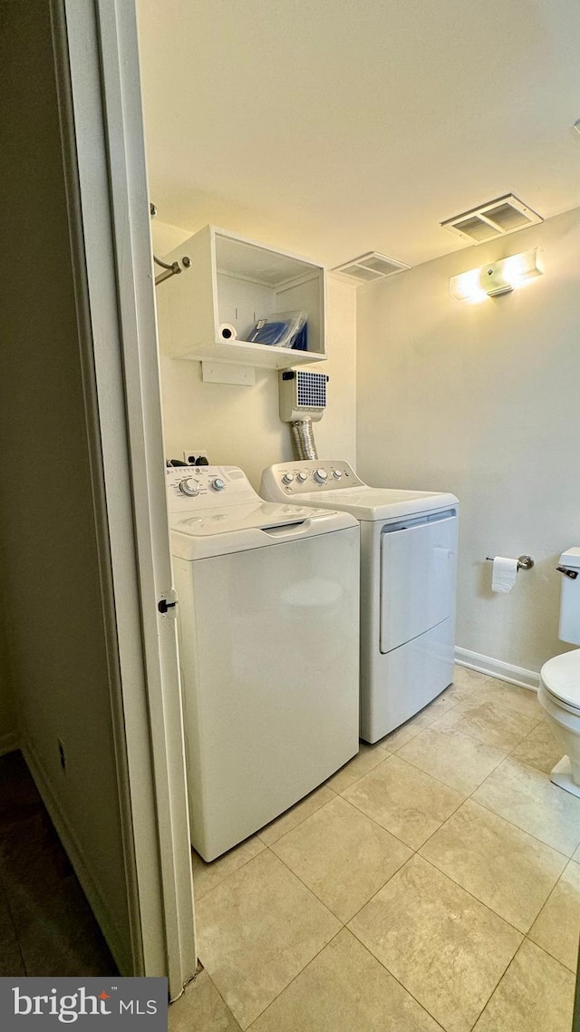 laundry area featuring washer and clothes dryer and light tile patterned floors