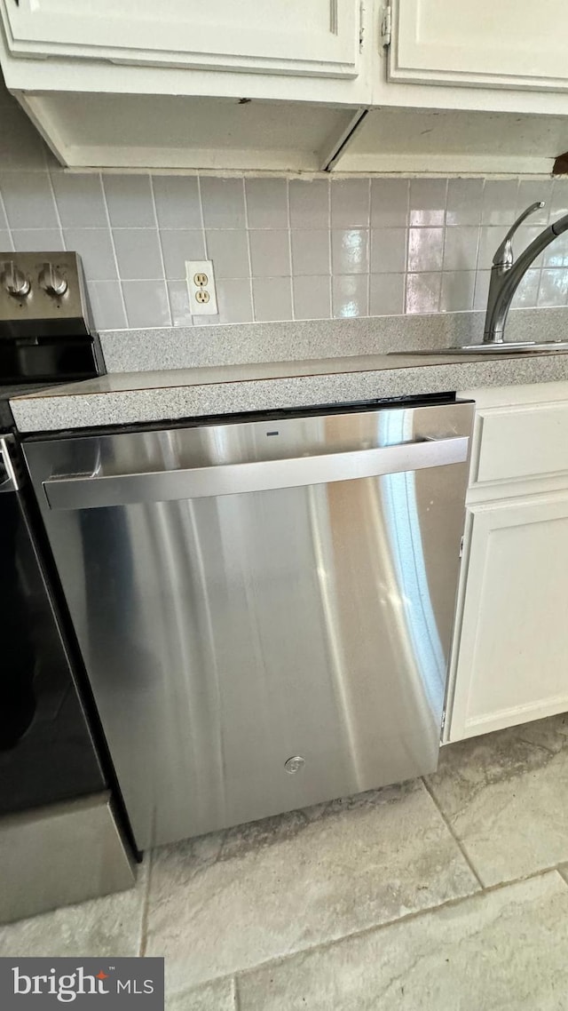 interior details with decorative backsplash, white cabinets, and stainless steel dishwasher