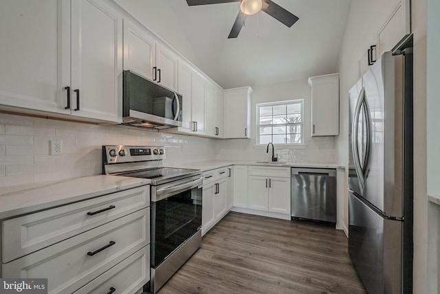 kitchen featuring ceiling fan, stainless steel appliances, dark wood-type flooring, white cabinets, and sink