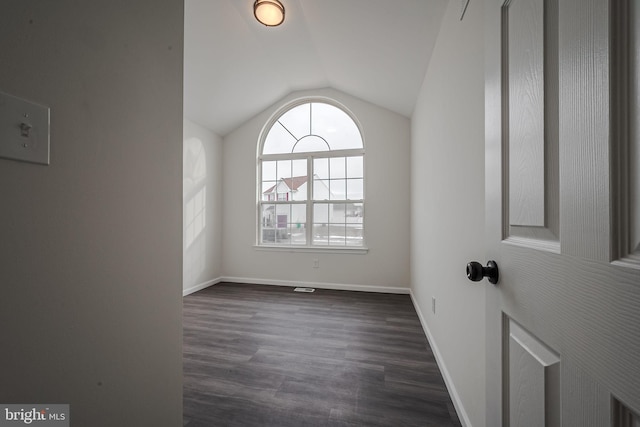 spare room with lofted ceiling and dark hardwood / wood-style floors