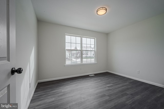 spare room with dark wood-type flooring