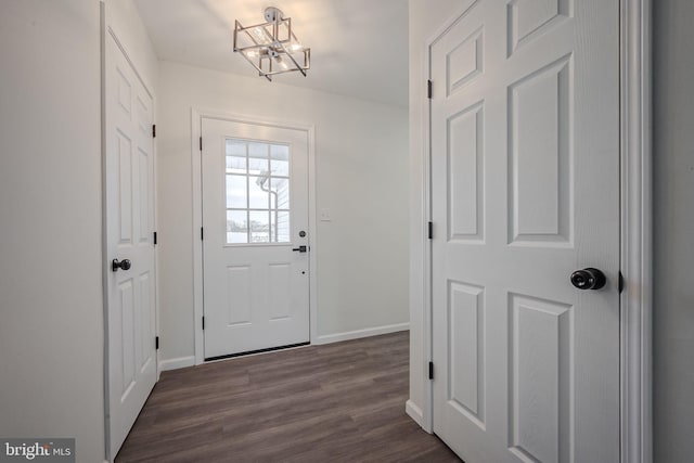 doorway to outside with dark hardwood / wood-style floors and a notable chandelier