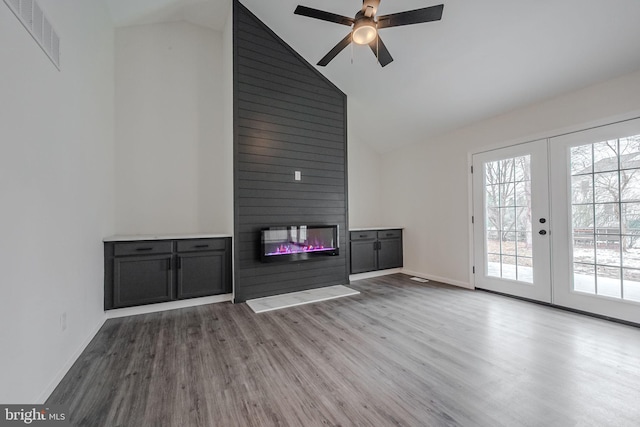 unfurnished living room with ceiling fan, french doors, vaulted ceiling, and light wood-type flooring