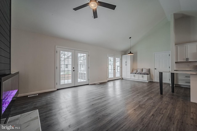 unfurnished living room featuring dark hardwood / wood-style floors, ceiling fan, french doors, and high vaulted ceiling