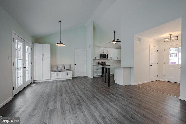 unfurnished living room featuring high vaulted ceiling, french doors, dark hardwood / wood-style flooring, and ceiling fan with notable chandelier