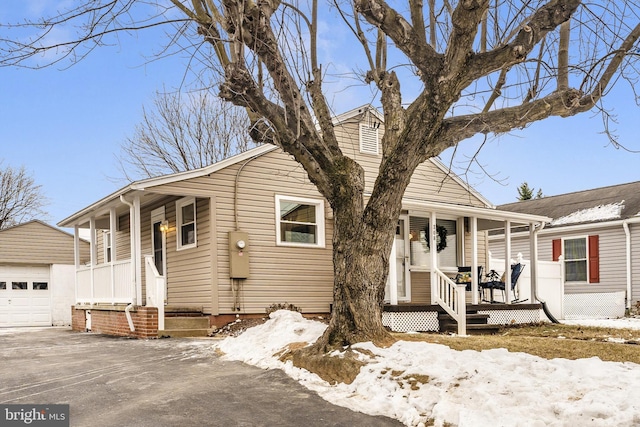 view of front of house featuring a garage, an outdoor structure, and a porch