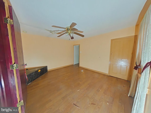 empty room with wood-type flooring and ceiling fan