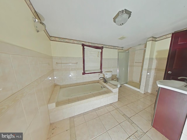 full bathroom featuring tile walls, vanity, tile patterned floors, shower with separate bathtub, and toilet