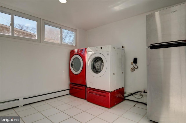 laundry area featuring baseboard heating, washer and dryer, and light tile patterned floors