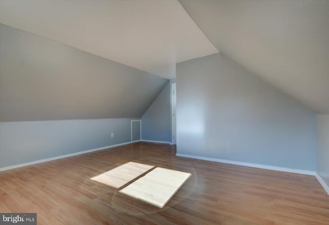 bonus room with lofted ceiling and light wood-type flooring