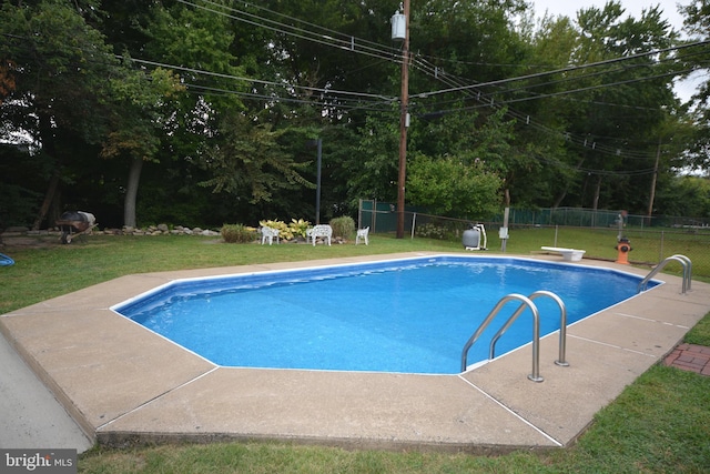 view of swimming pool featuring a patio, a diving board, and a lawn